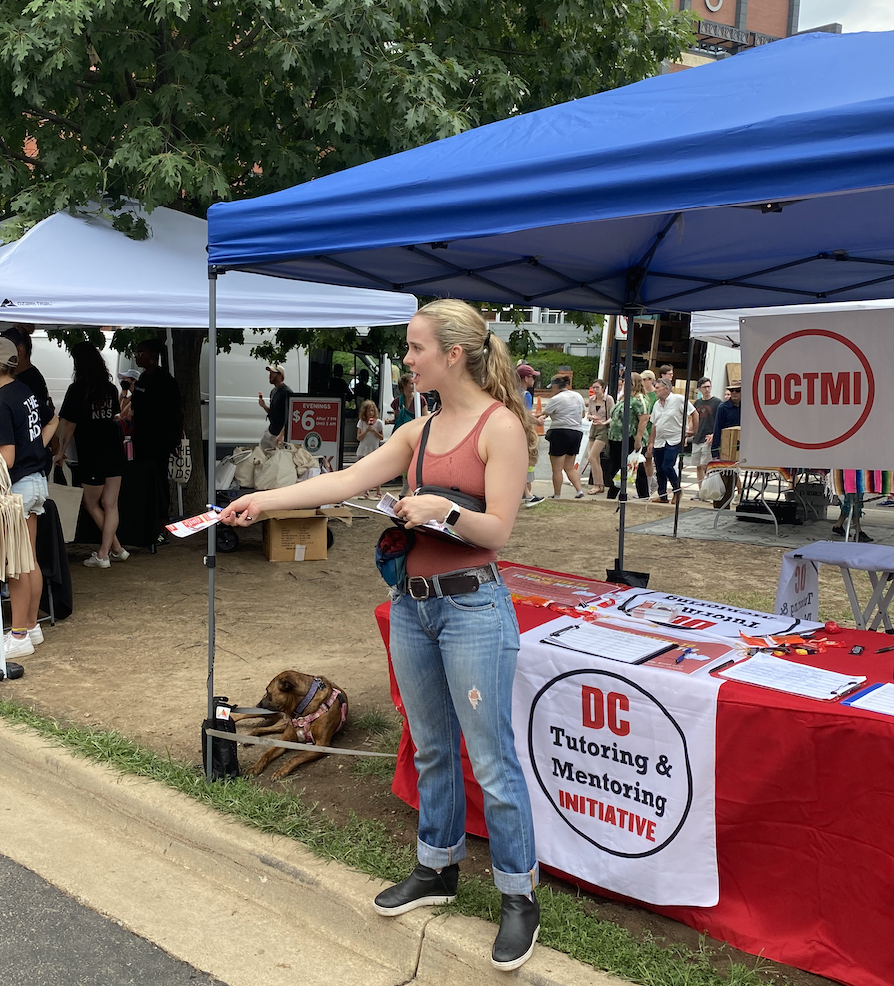 DC volunteer opportunities - woman passing out flyers at farmers market